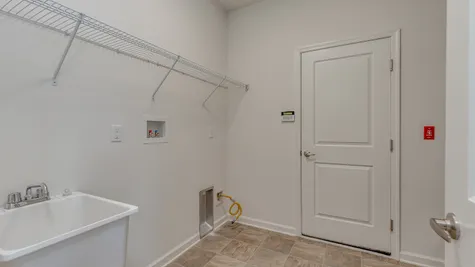 Convenient laundry area that includes a wire shelf for storage inside the Zinnia model.
