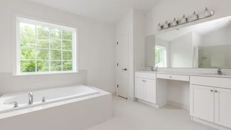 Baldwin master bathroom with soaking tub, large double sink vanity and large window over tub