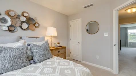3rd floor bedroom in the Parc townhome model with full size bed and closet.
