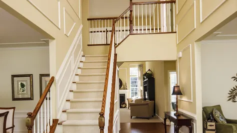 Stair case in front hall of Baldwin model new home, wood floors, open landing upstairs.