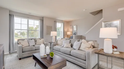 Tan colored couch and love seat placed with a coffee table in front within the living room area of this new townhome in South Jersey.