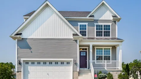 Exterior of the Laurelton Grand new home in south New Jersey with light gray siding and small porch on front.