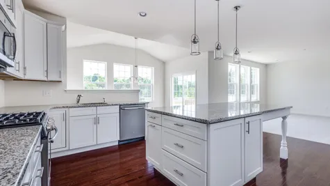 The Laurelton with white cabinets, gray tone granite counters, wood floor, optional morning room with many windows.
