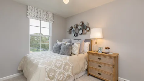 3rd floor bedroom in this South Jersey townhome model with full size bed and window.