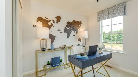 A bedroom converted into a home office, perfect for working from home, shown with a world map on the wall.