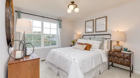 A full size bed within this third townhome bedroom which overlooks the front of the unit.