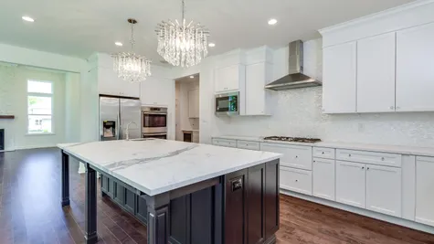 Brandywine model new home in NJ kitchen with white cabinets, two chandeliers & large center island.
