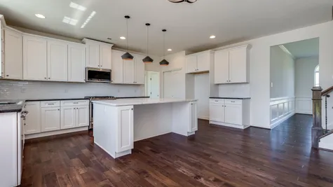 Baldwin kitchen with white cabinets and wood floors.