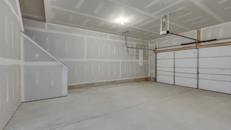 The stairs inside the garage provide easy access to an unfished storage area in the Zinnia model.