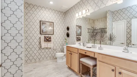 Wall paper is on all walls throughout this spacious Owner's Bathroom with double sinks and a large mirror above