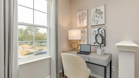 Cozy nook within living room space shown with office desk, perfect for working from home.