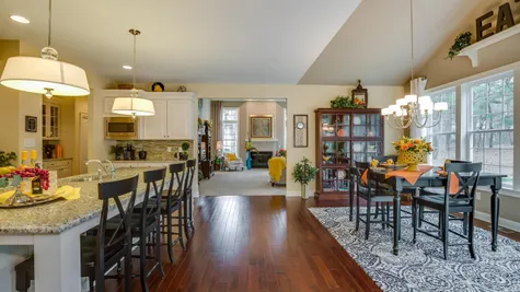 Brandywine model luxury new home in NJ kitchen & eating area with wood floors, center island, sample furniture.