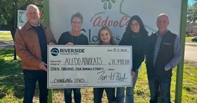 Image of the Riverside and Advocat teams with the donation check.