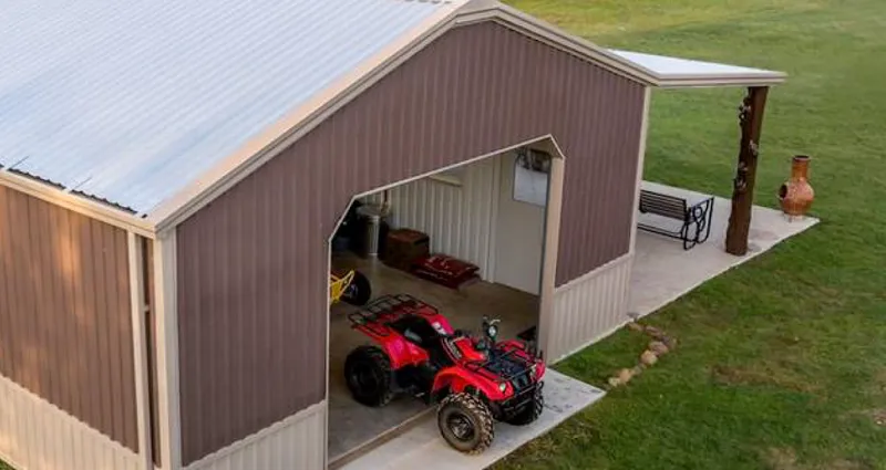 Brown outbuilding with a red tractor parked in front