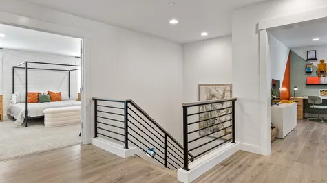 top of stairs at second level of home with open rail and hard surface flooring