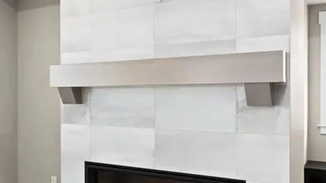Gas fireplace with ceiling-height tile and wood mantel
