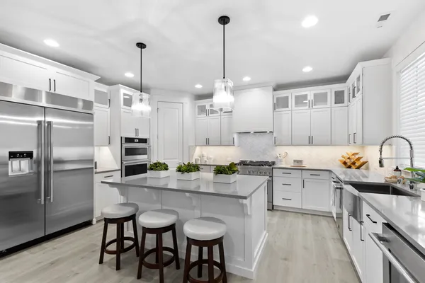 white on white kitchen with stainless appliances and a big island