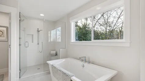 Freestanding soaking tub and walk-in shower with frameless glass door