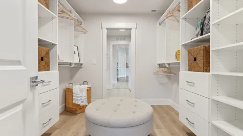 primary closet has custom built-ins and opens through to laundry room