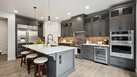 kitchen with slab quartz counters, dark wood cabinets, jenn air rise appliances