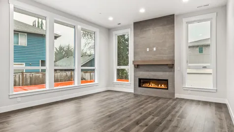 great room has gas fireplace with ceiling-height tile and wood mantel