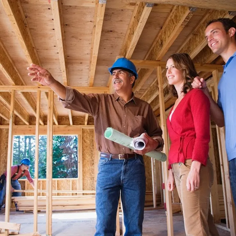 A construction professional talking with a couple representing the home building process as explained by Robertson Homes in Michigan