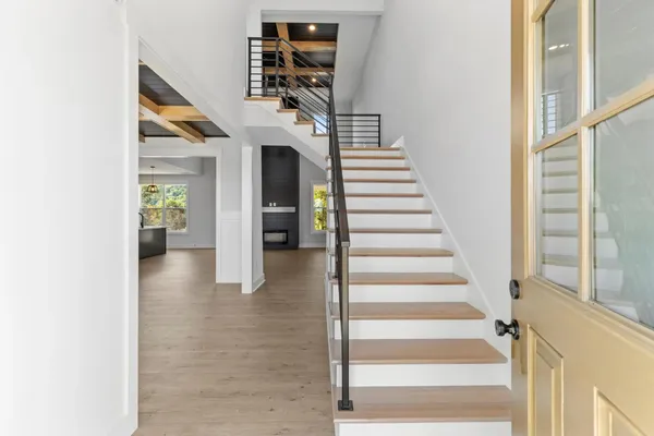 The Smokey staircase with wood treads, white risers, and a glass-panel door beside it