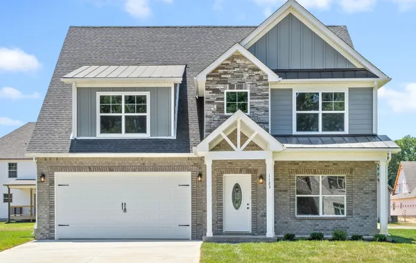 Two-story home with stone accents, gray siding, and a two-car garage at Summerfield by Rockwood Homes in Clarksville, TN.