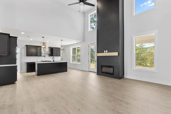The Smokey kitchen and living area with a black island, a tall black fireplace, and windows