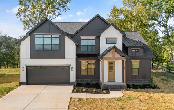 Front exterior of The Smokey by Rockwood Homes, a two-story home with white siding, black trim, and a black garage door.