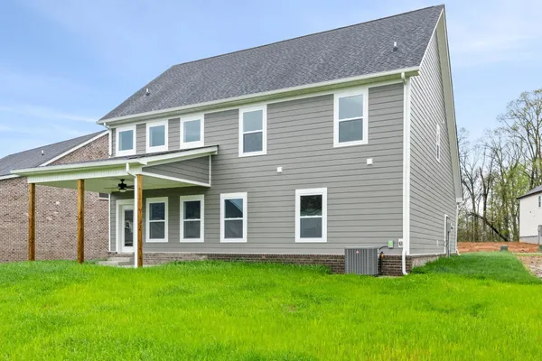 Rear exterior of The Brayden by Rockwood Homes, a two-story home with gray siding and a covered back patio.