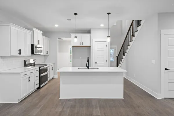 The Brayden kitchen with white cabinets, a center island, and stainless appliances