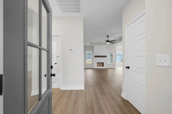 The Cumberland hallway with wood-look flooring leading to the living room