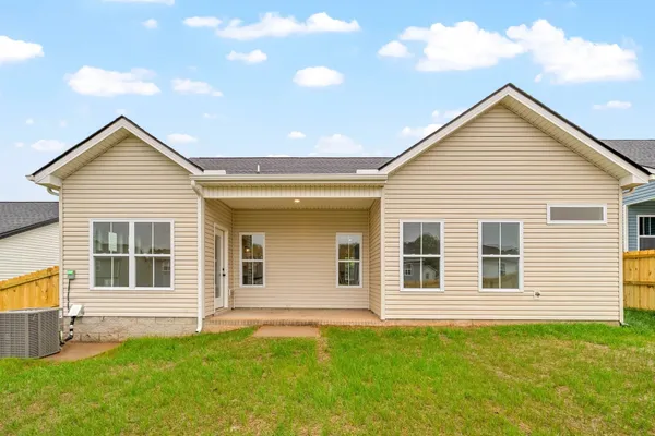 Rear exterior of The Cumberland by Rockwood Homes, a single-story home with tan siding and a covered back patio.