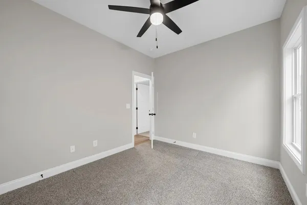 The Cumberland bedroom with carpet, a ceiling fan, and a window on the side wall