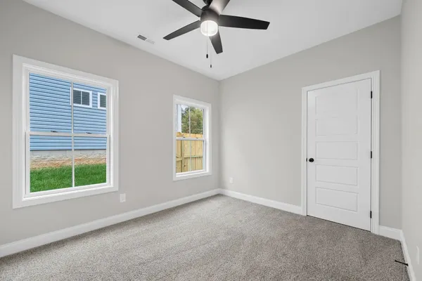 The Cumberland bedroom with carpet, a ceiling fan, and two windows