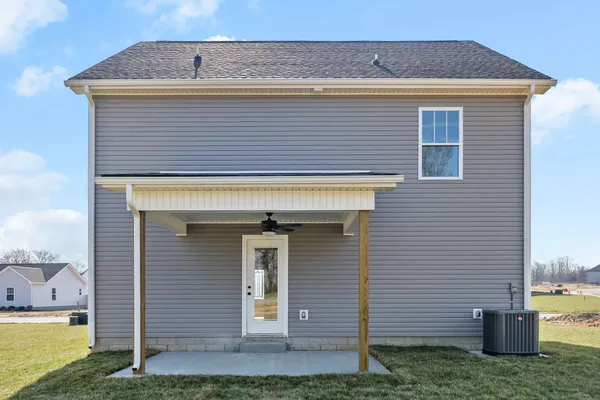 Rear exterior of The Maui by Rockwood Homes, a two-story home with gray siding and a covered back patio.