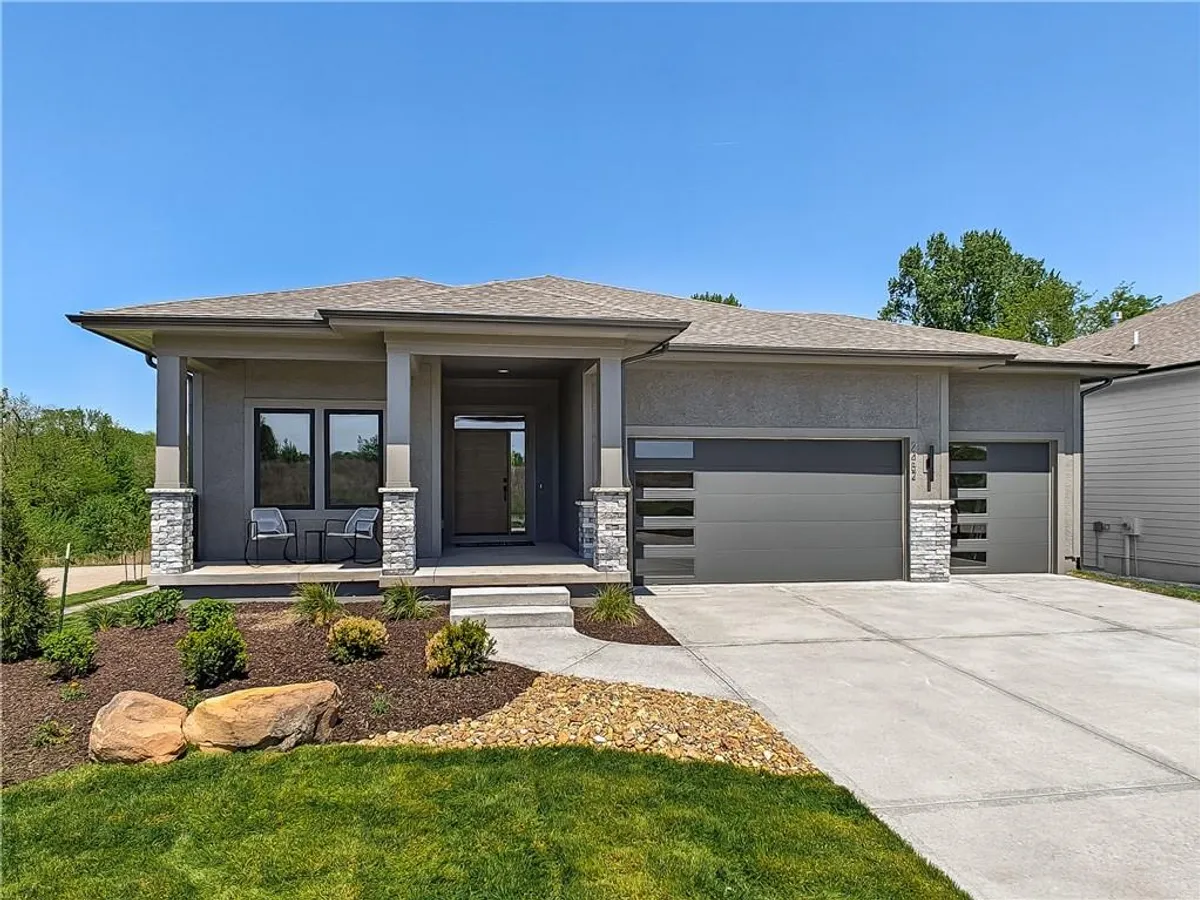 Contemporary stucco exterior featuring stone accents and a covered porch