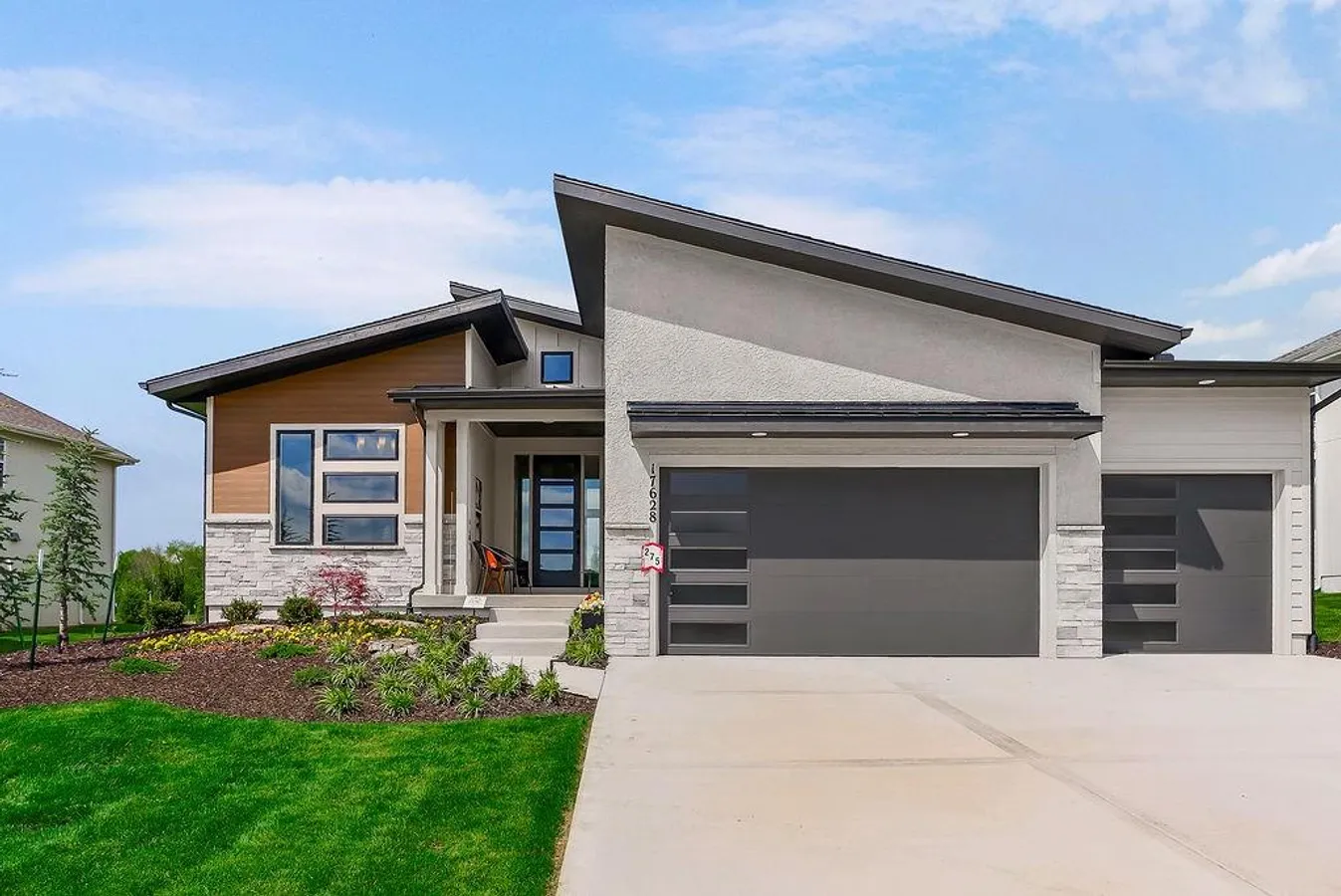 Modern exterior featuring a prominent asymmetrical roofline, stucco siding, and stone accents
