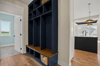Built-in storage unit with wood-finish bench, wood-finish flooring, and pendant lighting