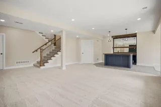 Spacious recreation area featuring plush carpeting and recessed lighting