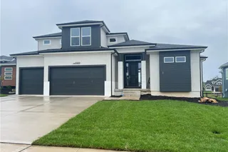 Clean lines and a spacious concrete driveway define this modern two-story home design.
