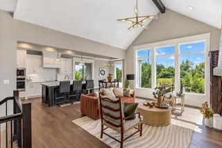 Soaring vaulted ceilings and expansive windows illuminate this open-concept main-level living space. PHOTO IS OF ACTUAL  HOME.