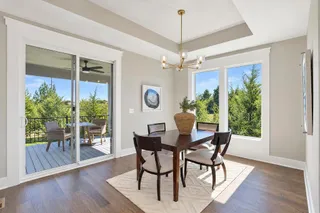 Hardwood floors and a recessed ceiling define this dining space looking out to the deck.
