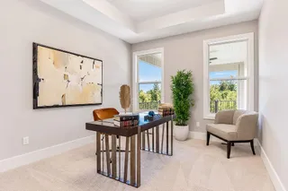 Double windows frame leafy outdoor views, illuminating the classic tray ceiling and soft carpeted flooring. PHOTO IS OF ACTUAL  HOME.