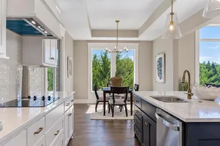 Gleaming hardwood floors and a tray ceiling flow seamlessly from the kitchen into the dining area.