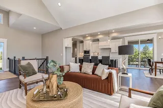 Hardwood floors and vaulted ceilings frame this open living space leading to the kitchen. PHOTO IS OF ACTUAL  HOME.