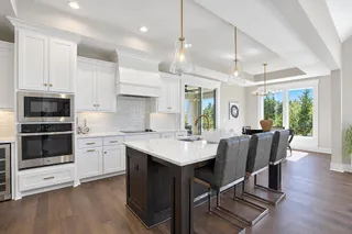 Gleaming hardwood floors and a spacious island anchor this bright kitchen with custom cabinetry. PHOTO IS OF ACTUAL HOME.