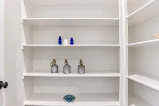 Custom built-in shelving offers abundant storage space within this walk-in closet. PHOTO IS OF ACTUAL  HOME.
