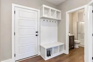 Rich hardwood flooring complements a functional drop zone and entryway built-ins. PHOTO IS OF ACTUAL  HOME.